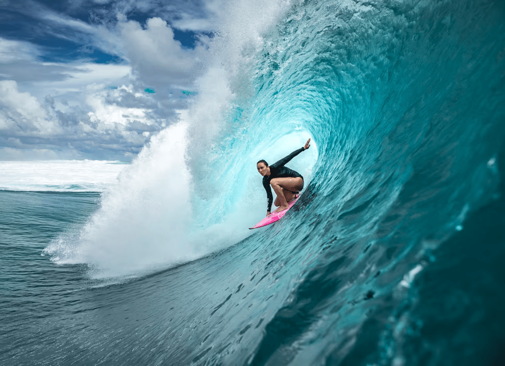 Female surfer surfing a big blue wave