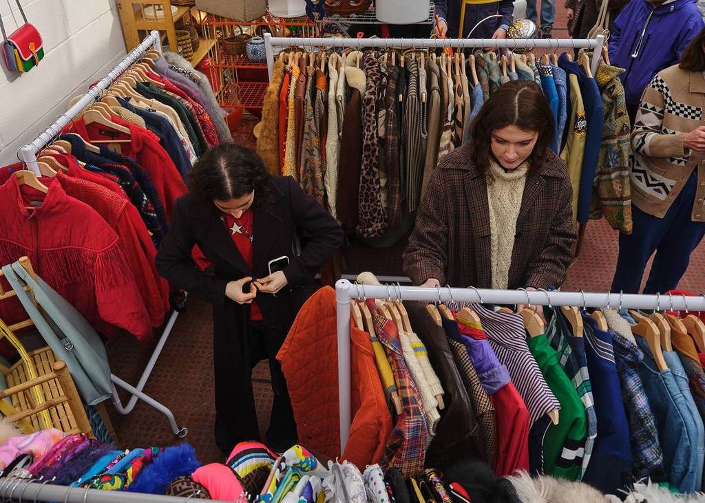 personas mirando prendas en un mercadillo